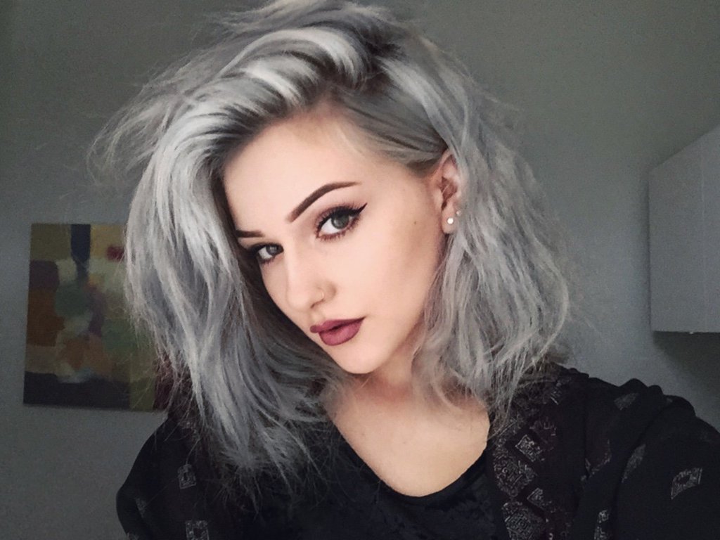 Luce un hermoso cabello gris con sus ojos pintados y la piel blanca