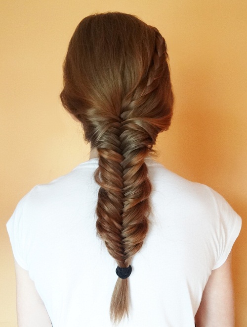 Mujer con cabello castaño luciendo una trenza de espigas