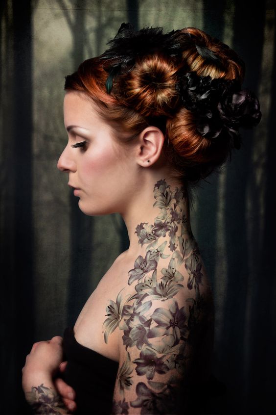 Joven mujer con un tatuaje de flores en el brazo