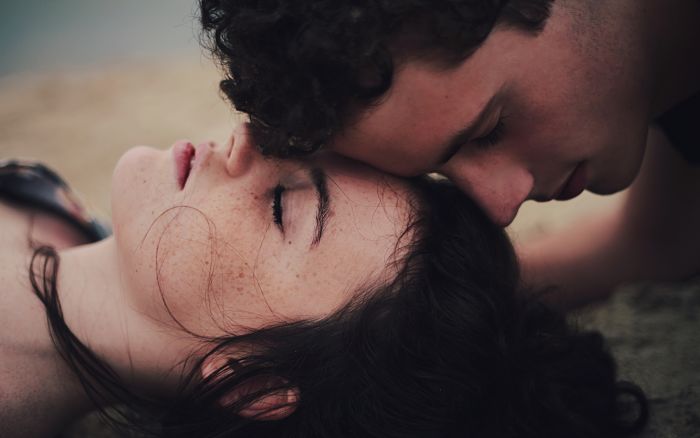 Pareja de jóvenes acostados en el suelo con los ojos cerrados, amor ciego