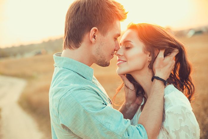 Pareja joven dándose un beso porque besar es saludable
